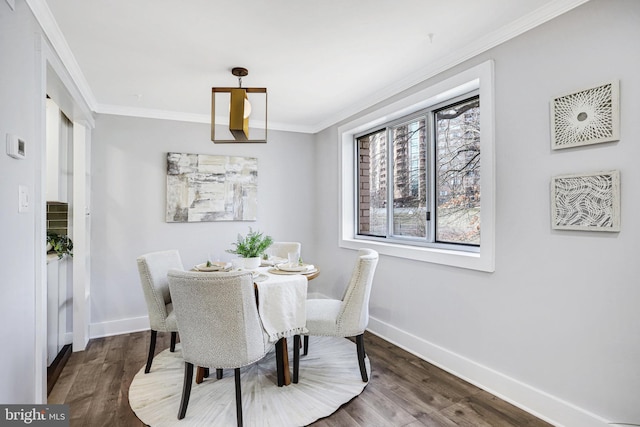 dining area with dark wood-type flooring and crown molding