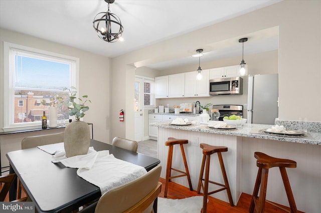 dining area with hardwood / wood-style floors and a chandelier