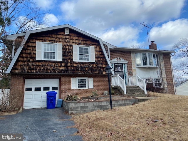 view of front of house featuring a garage, brick siding, a gambrel roof, driveway, and a chimney