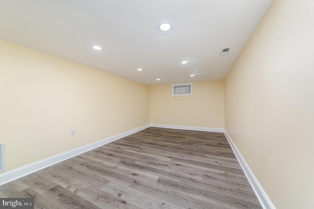 empty room with baseboards, visible vents, wood finished floors, and recessed lighting