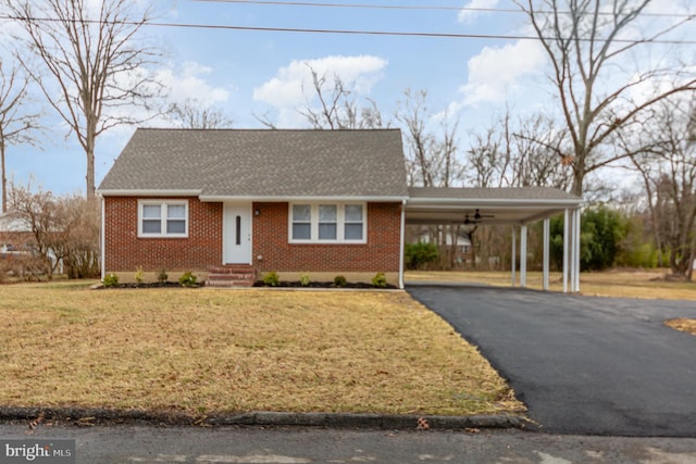 view of front of property with a carport, aphalt driveway, a front lawn, and brick siding