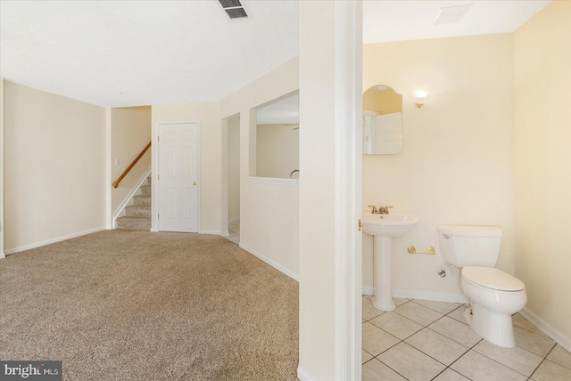 interior space with tile patterned flooring, visible vents, toilet, baseboards, and a sink