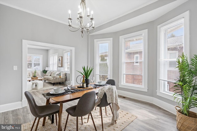 dining room featuring light hardwood / wood-style floors, an inviting chandelier, and ornamental molding