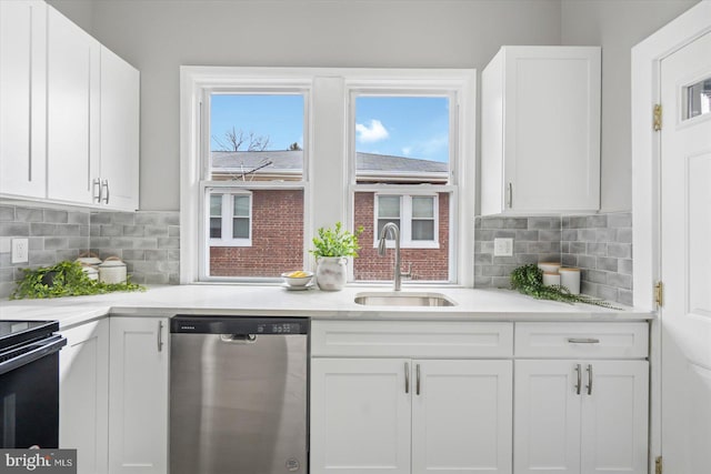 kitchen with stove, white cabinets, stainless steel dishwasher, backsplash, and sink