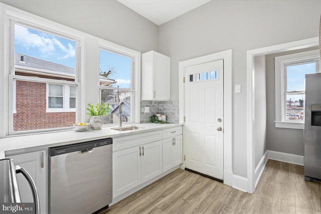 kitchen with sink, stainless steel appliances, white cabinets, and backsplash