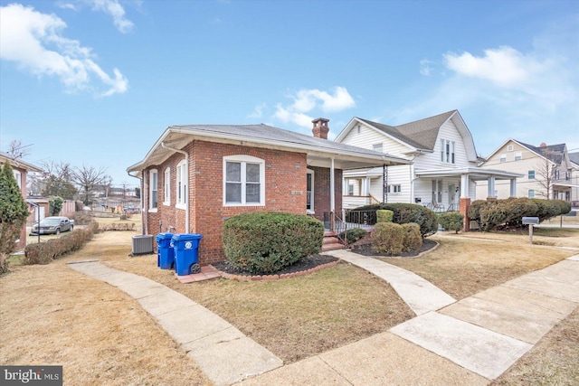 bungalow with covered porch and a front lawn