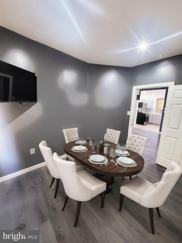 dining area with baseboards and wood finished floors