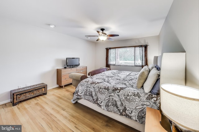 bedroom featuring light wood-style floors, baseboards, and a ceiling fan