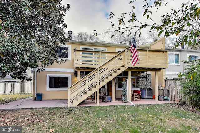 rear view of property with a lawn, stairs, fence, a patio area, and stucco siding