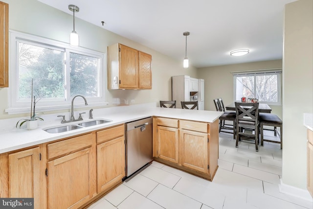 kitchen with a sink, pendant lighting, light countertops, and dishwasher