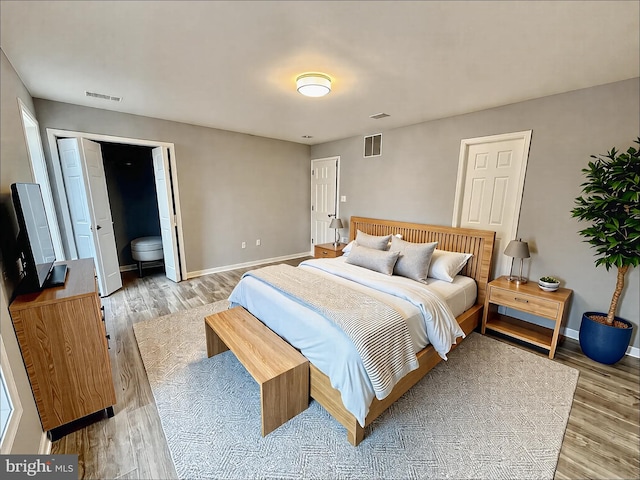 bedroom with baseboards, visible vents, and light wood-type flooring