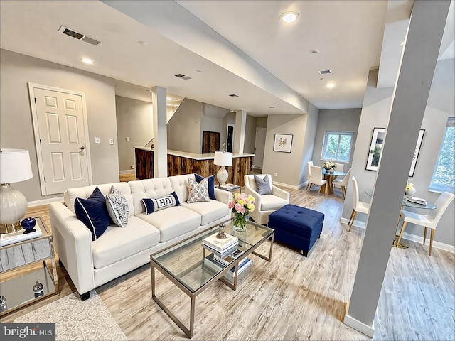 living area featuring light wood-type flooring, visible vents, baseboards, and recessed lighting