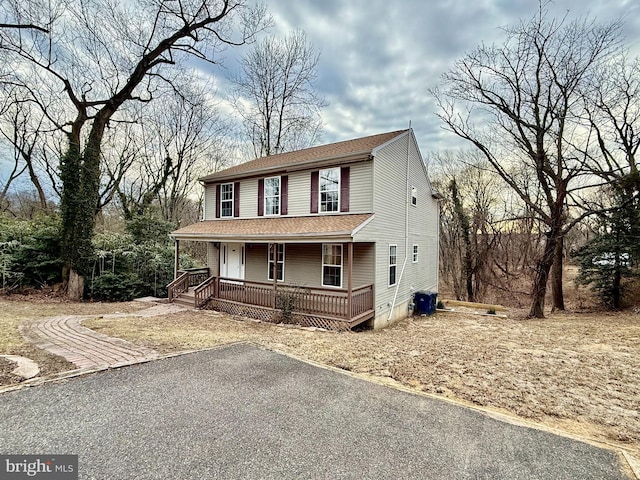 view of front of house with covered porch and a shingled roof