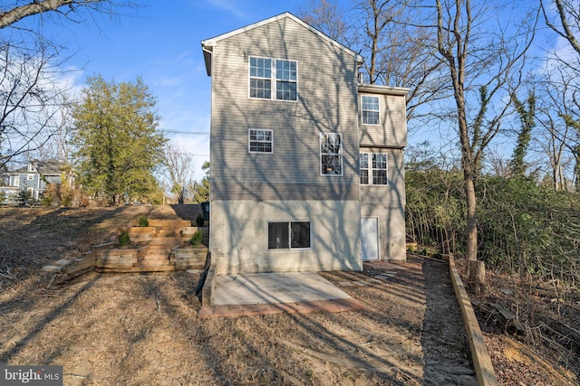 back of property with stucco siding and a patio