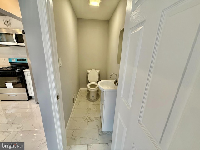 bathroom with marble finish floor, toilet, vanity, and baseboards