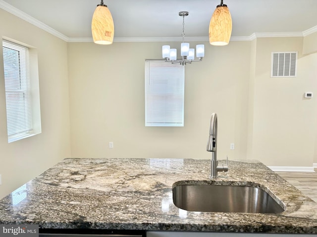 kitchen with visible vents, dark stone counters, ornamental molding, wood finished floors, and a sink