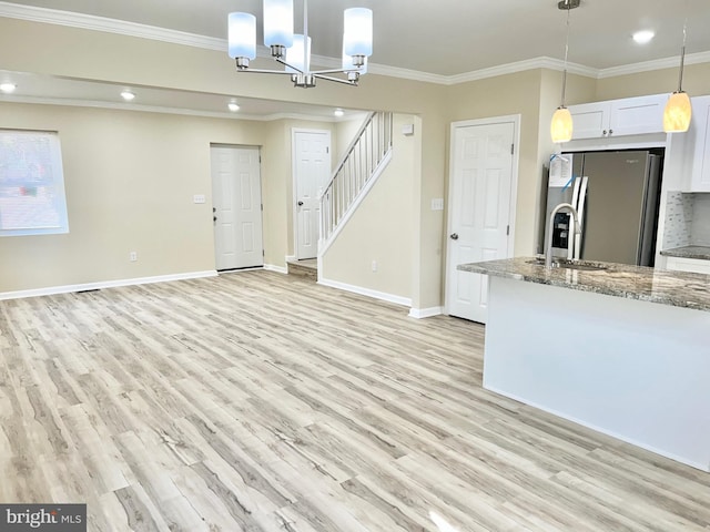 interior space featuring light wood-style floors, stainless steel fridge, and crown molding