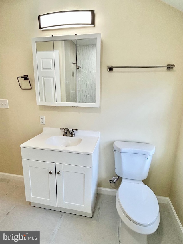 bathroom featuring toilet, vanity, and baseboards