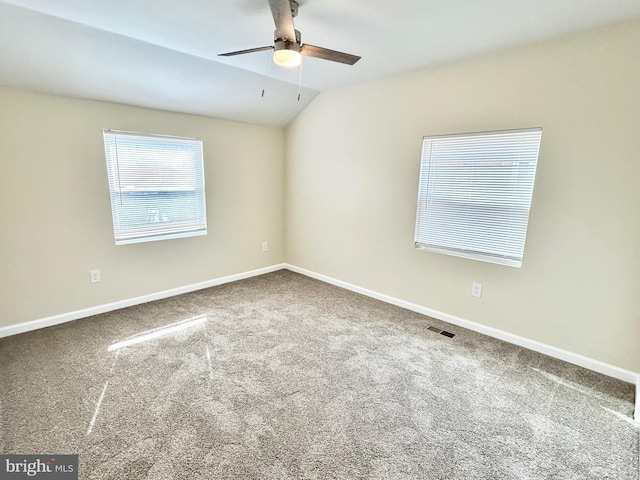 unfurnished room featuring lofted ceiling, carpet flooring, visible vents, and baseboards