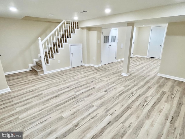 finished below grade area with stairs, wood finished floors, and baseboards