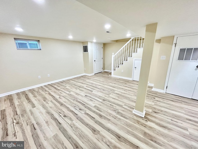 finished below grade area featuring visible vents, baseboards, stairs, light wood-style floors, and recessed lighting