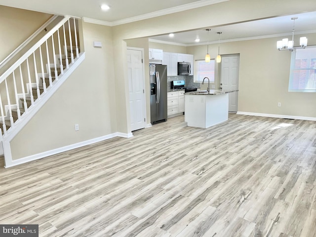 kitchen with open floor plan, stainless steel appliances, a sink, and light wood-style floors