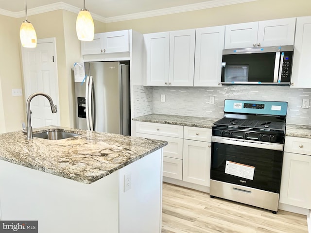 kitchen featuring ornamental molding, stainless steel appliances, light wood-type flooring, white cabinetry, and a sink