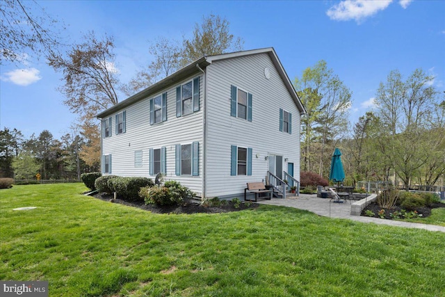 back of house with a patio and a yard