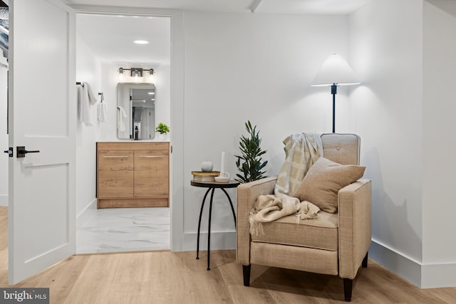 sitting room featuring light wood finished floors and baseboards