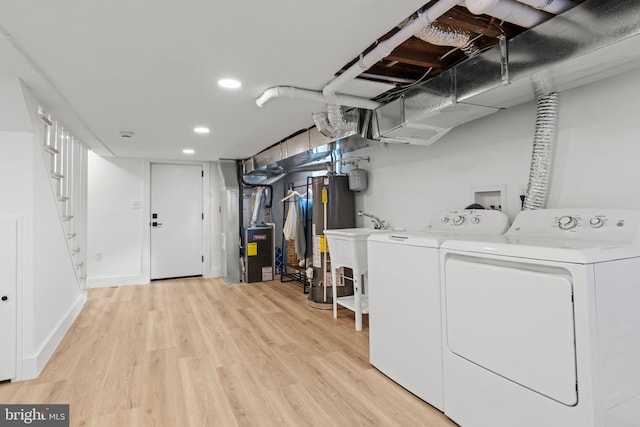 laundry area featuring laundry area, washer and clothes dryer, light wood-style flooring, water heater, and recessed lighting