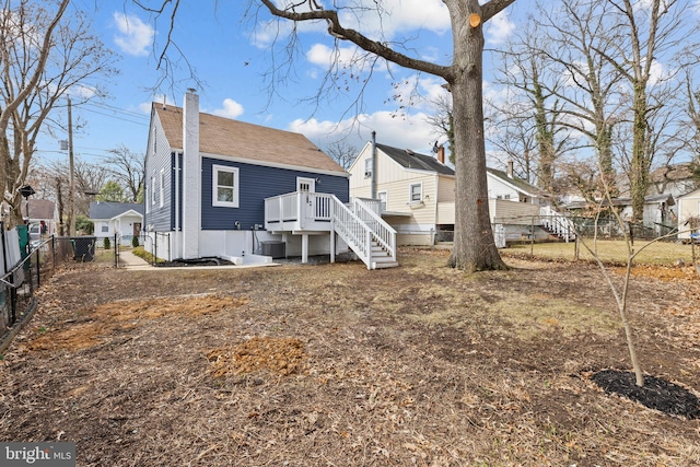 rear view of property with a fenced backyard, a shingled roof, a residential view, a gate, and a chimney