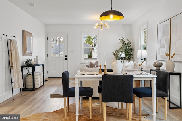 dining space with a chandelier and light wood-type flooring