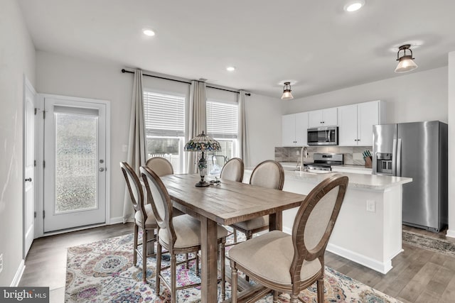 dining room with recessed lighting, baseboards, and wood finished floors