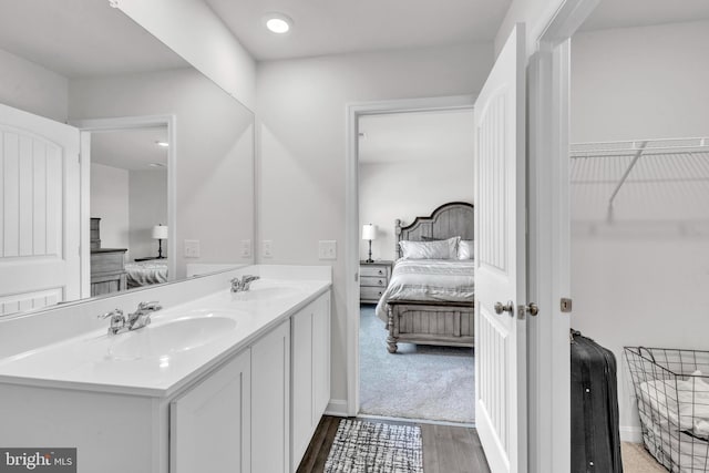 bathroom featuring ensuite bathroom, wood finished floors, and a sink