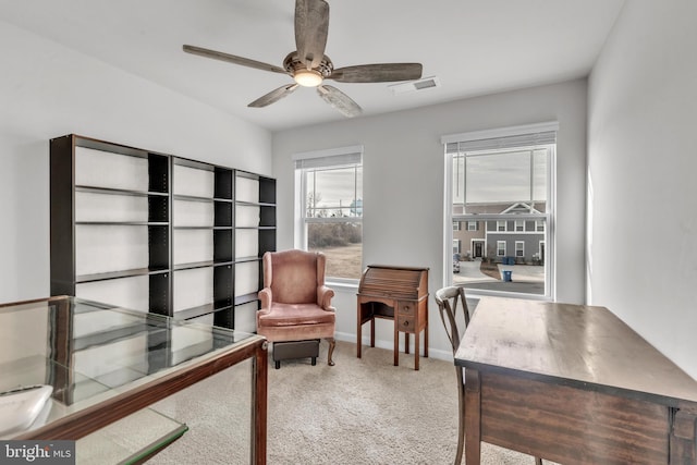 carpeted office space featuring ceiling fan, visible vents, and baseboards