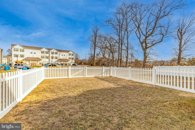 view of yard featuring a fenced backyard and a residential view