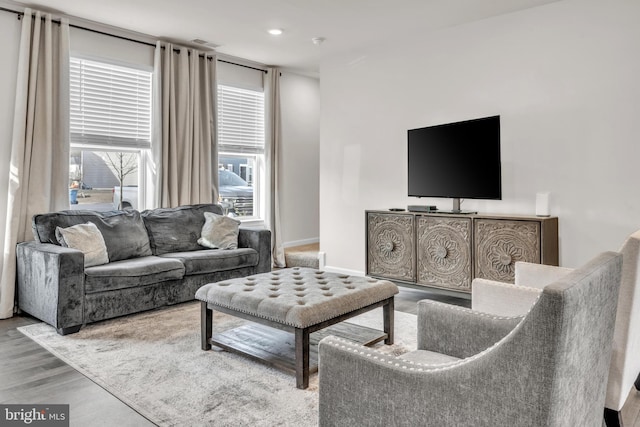 living room featuring light wood-style floors, baseboards, visible vents, and recessed lighting