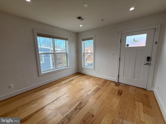 foyer entrance with light wood-type flooring, baseboards, visible vents, and recessed lighting