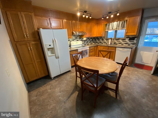 kitchen with white appliances, light countertops, decorative backsplash, and a sink