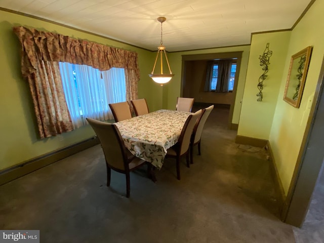 dining space featuring baseboards, dark carpet, and ornamental molding