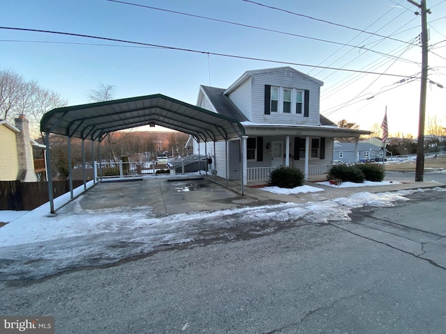 view of front of house with fence, a porch, and a detached carport