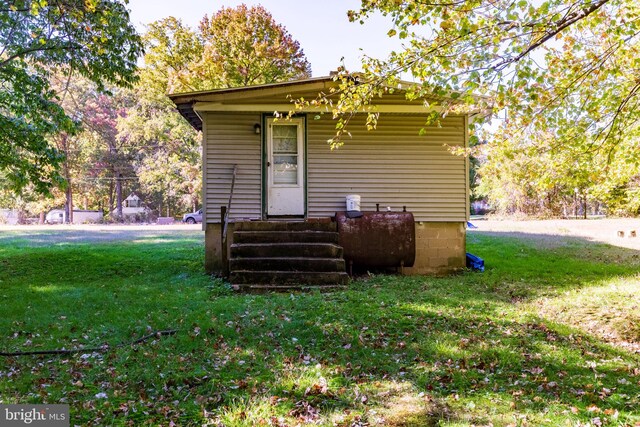 exterior space with entry steps, a yard, and heating fuel