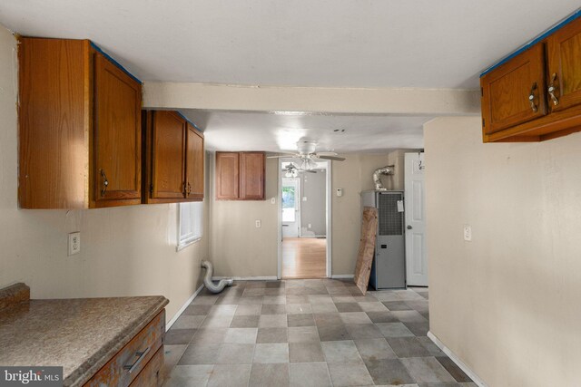 kitchen with brown cabinets, ceiling fan, and baseboards