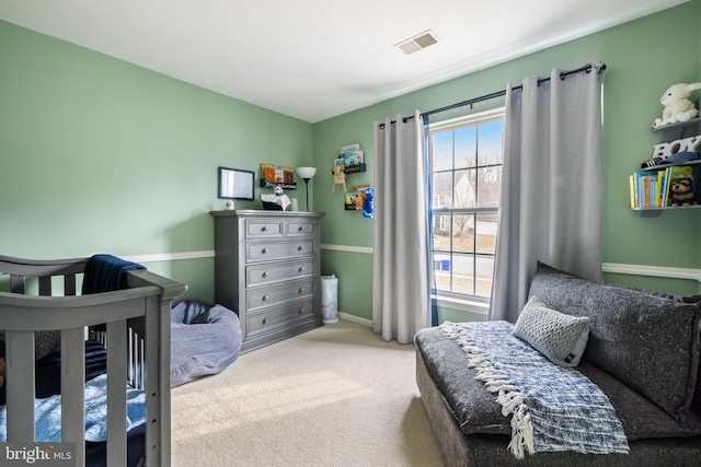 bedroom featuring visible vents and light colored carpet