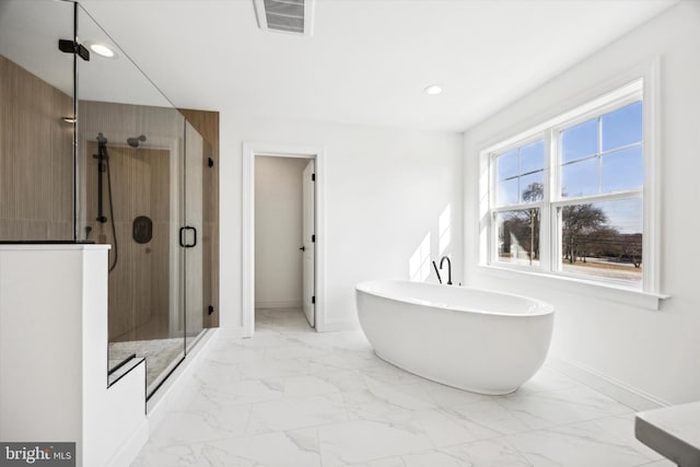 bathroom featuring marble finish floor, a stall shower, baseboards, visible vents, and a freestanding tub