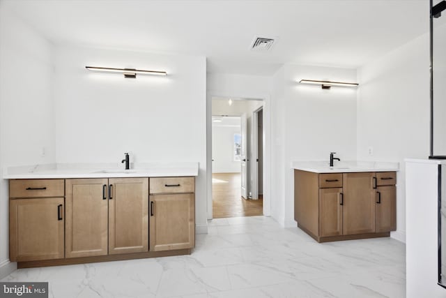 bathroom with a sink, visible vents, two vanities, and marble finish floor