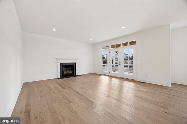 unfurnished living room with recessed lighting, light wood-style floors, and baseboards