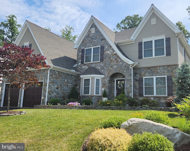 view of front of house featuring a front lawn, roof with shingles, and stucco siding