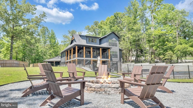 back of property with a yard, an outdoor fire pit, a patio area, and fence