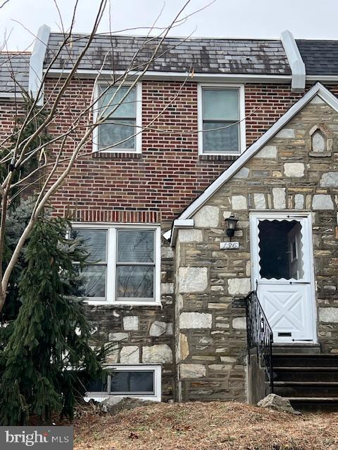 exterior space featuring entry steps, stone siding, and brick siding